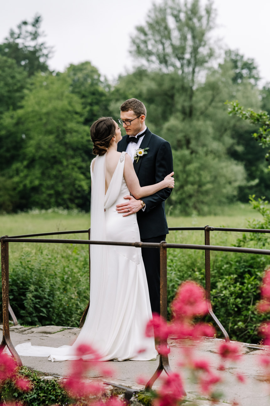 SUMMER WEDDING AT THE SWAN HOTEL BIBURY 42 wedding portrait of couple on the bridge in Bibury village.
