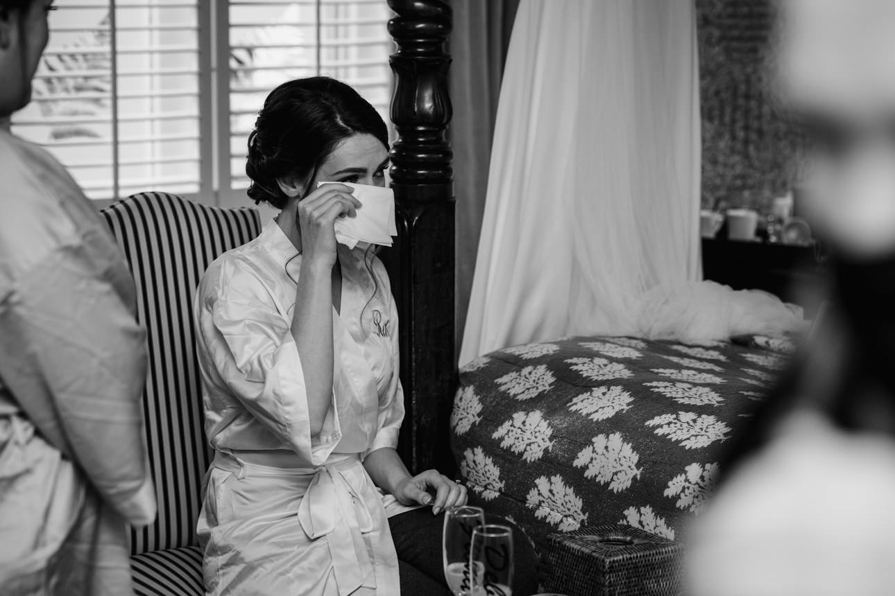 SUMMER WEDDING AT THE SWAN HOTEL BIBURY 11 Black and white photo of a bride adjusting her veil before her summer wedding at the Swan Hotel Bibury.