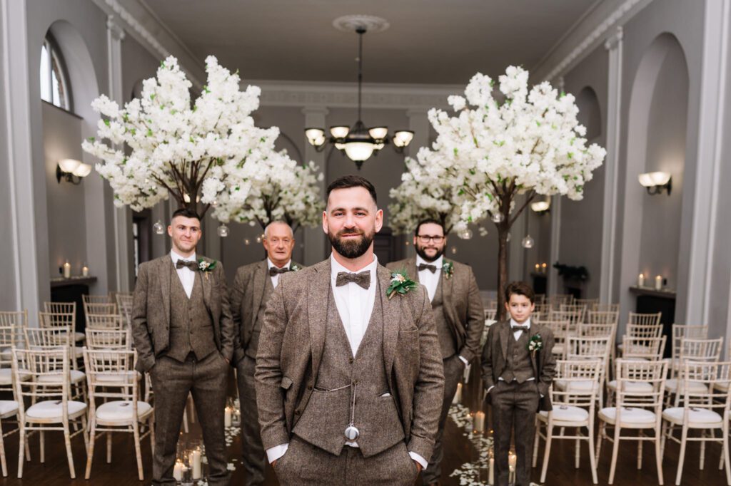 A CHRISTMAS WINTER WEDDING AT THE KINGS HEAD 18 Groom standing at the altar surrounded by wedding guests and white blossom arrangements