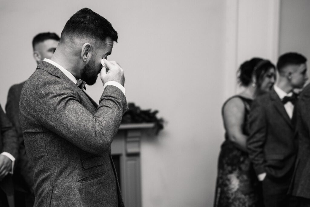A CHRISTMAS WINTER WEDDING AT THE KINGS HEAD 19 Groom wiping away an emotional tear during the wedding ceremony