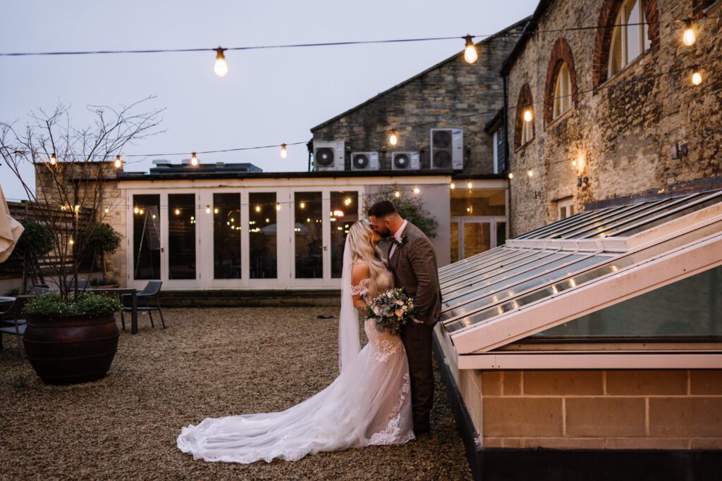 A CHRISTMAS WINTER WEDDING AT THE KINGS HEAD 32 Bride and groom embracing outside the Kings Head Hotel at dusk