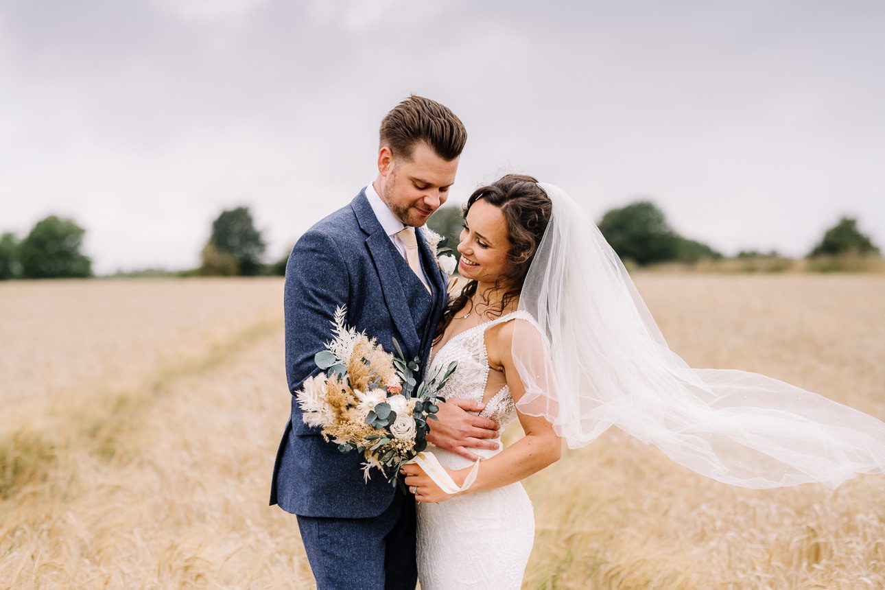 Stone barn wedding couple in wheat field_gallery