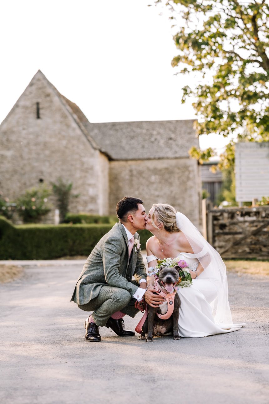 bride and groom with their dog at their wedding