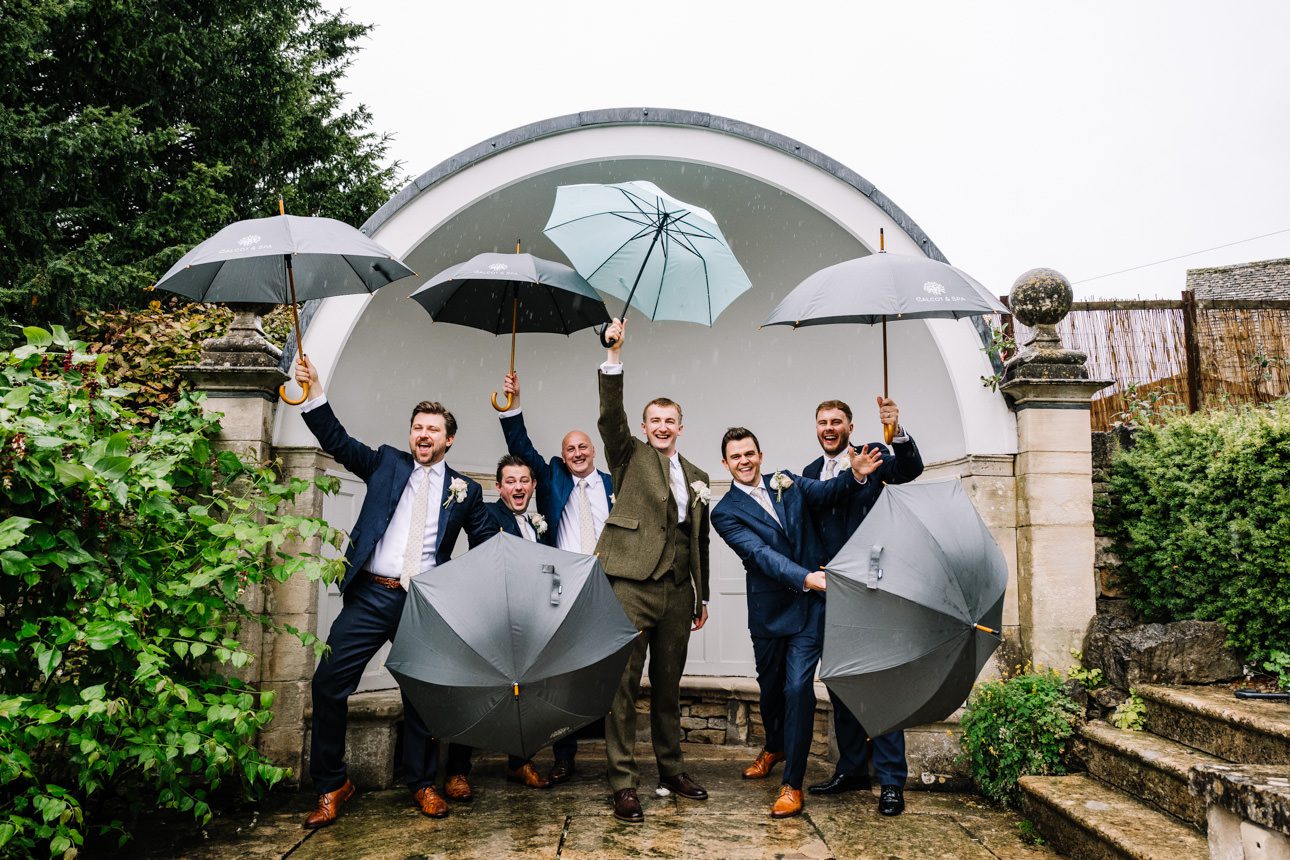 Groom and groomsmen with umbrellas