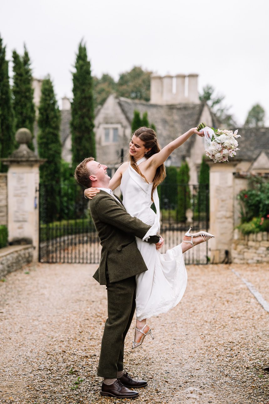 groom lifting bride up at the Painswick