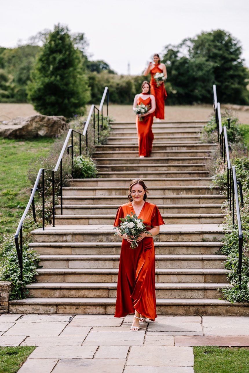 Bridesmaids walking down the aisle at the Barn at Upcote wedding venue