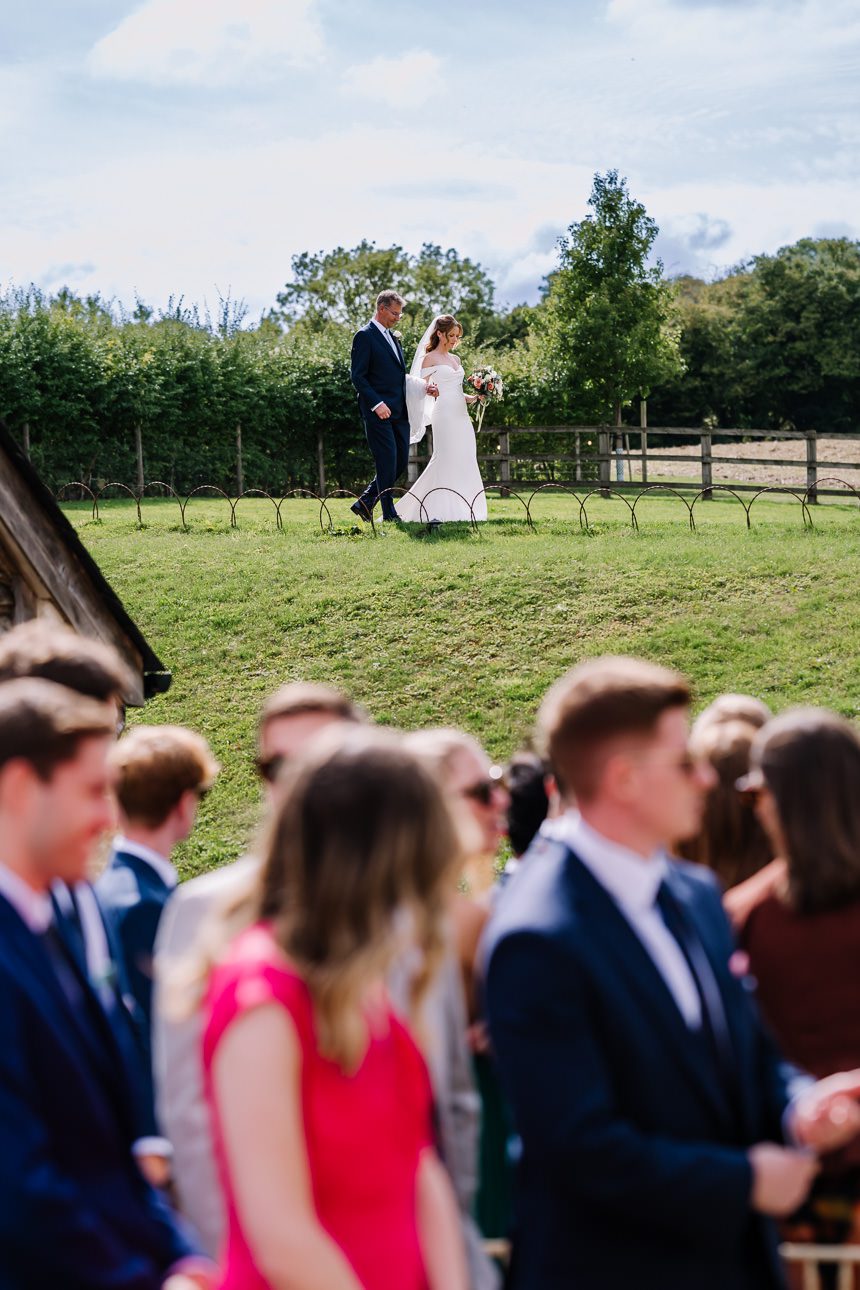 Bride arriving at the aisle for summer wedding at Upcote Barn.