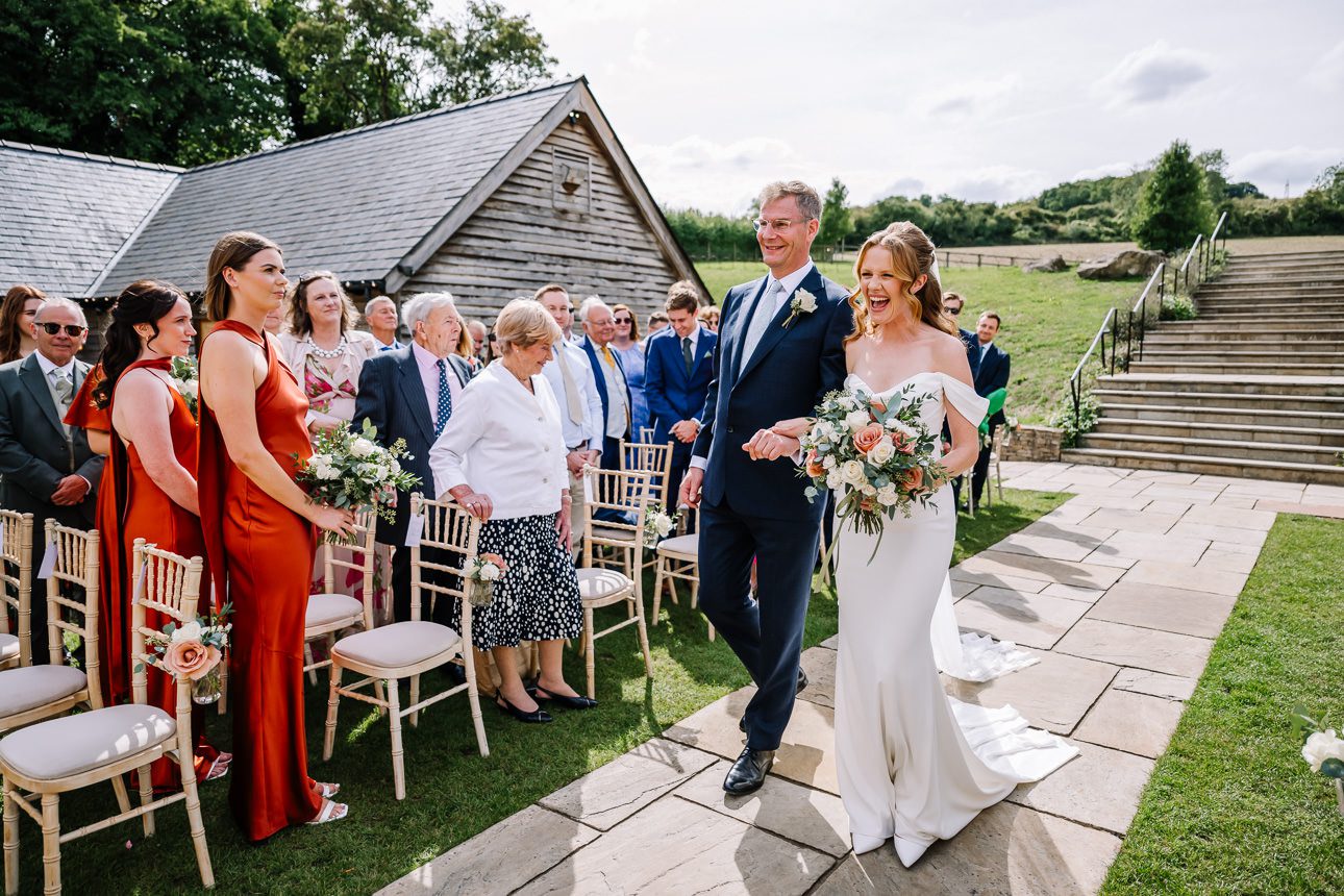 Bride arriving at the aisle for summer wedding at Upcote Barn.