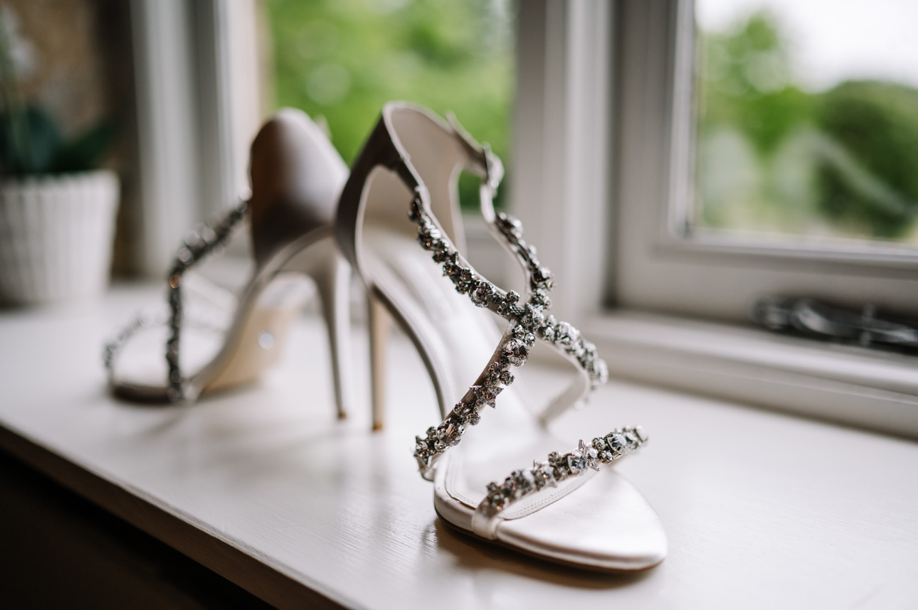 LAPSTONE BARN WEDDING PHOTOGRAPHER 22 Elegant embellished bridal heels displayed on a window sill at Lapstone Barn.