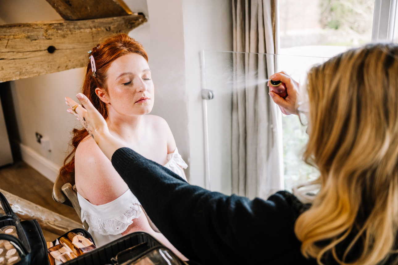 LAPSTONE BARN WEDDING PHOTOGRAPHER 18 Professional wedding makeup application with setting spray for a bride at Lapstone Barn.