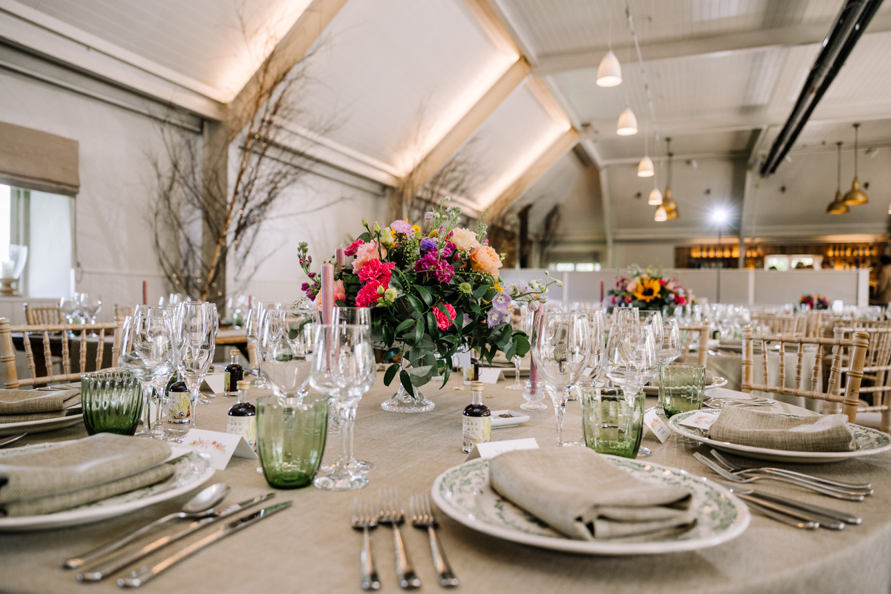 LAPSTONE BARN WEDDING PHOTOGRAPHER 75 Close-up photography of rustic wedding table decorations, floral centerpieces, and glassware at Lapstone Barn.
