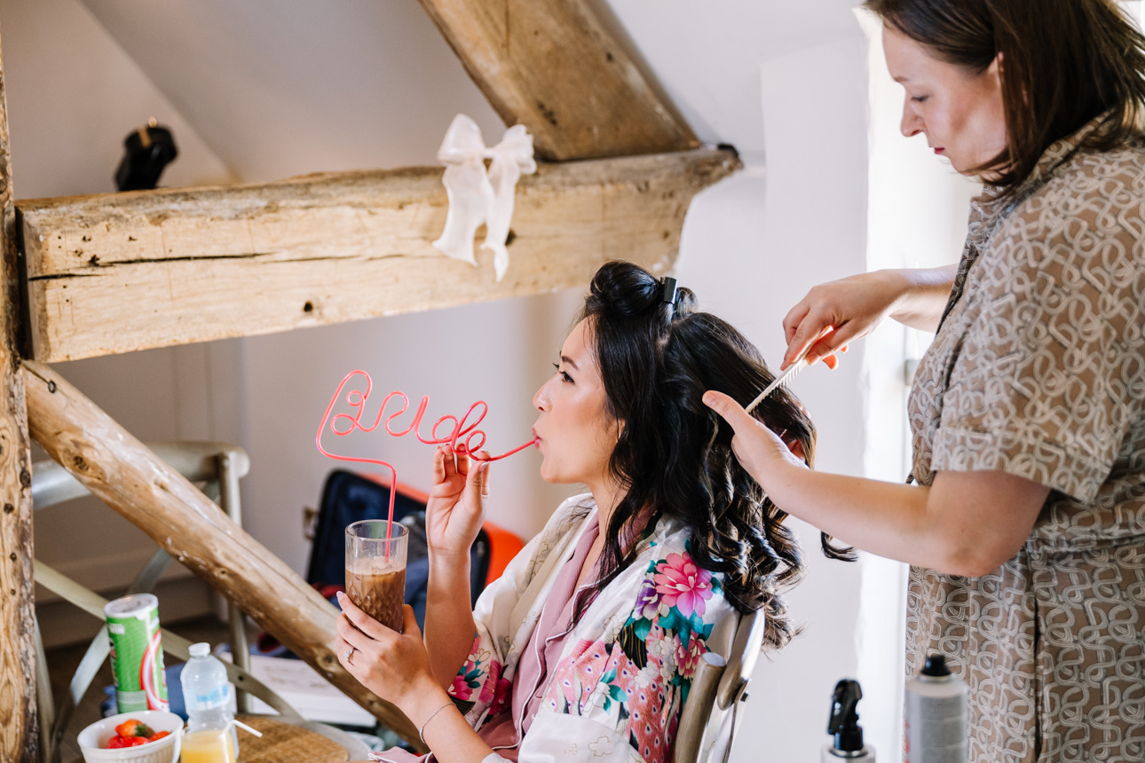 LAPSTONE BARN WEDDING PHOTOGRAPHER 13 Bridal preparation photography at Lapstone Barn showing a bride in a floral robe getting her hair styled.