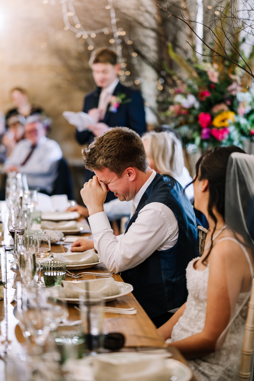 LAPSTONE BARN WEDDING PHOTOGRAPHER 78 Candid documentary wedding photography by Tanli Joy Weddings showing a guest laughing during speeches at Lapstone Barn.