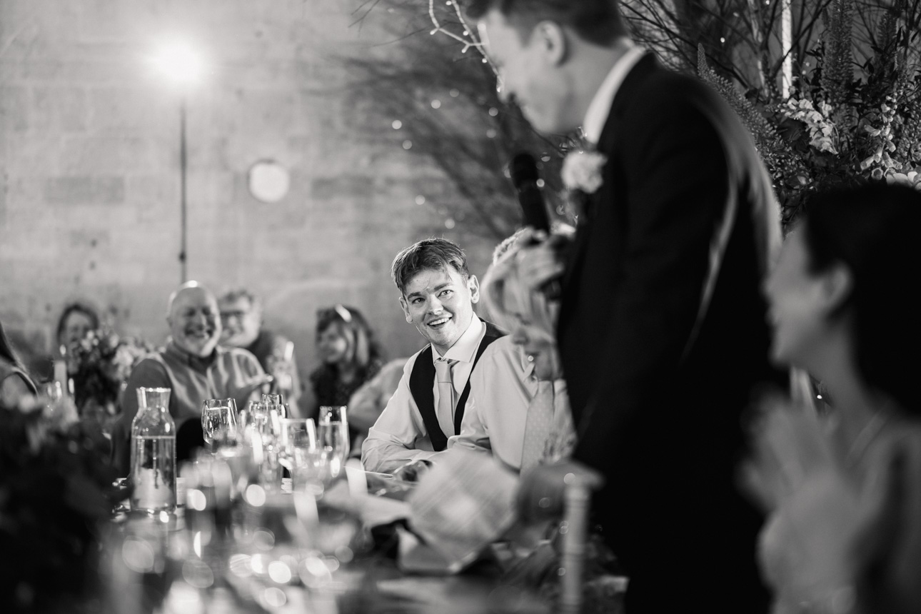 LAPSTONE BARN WEDDING PHOTOGRAPHER 97 A groom smiling and laughing during the wedding reception speeches captured by Tanli Joy Weddings at Lapstone Barn.