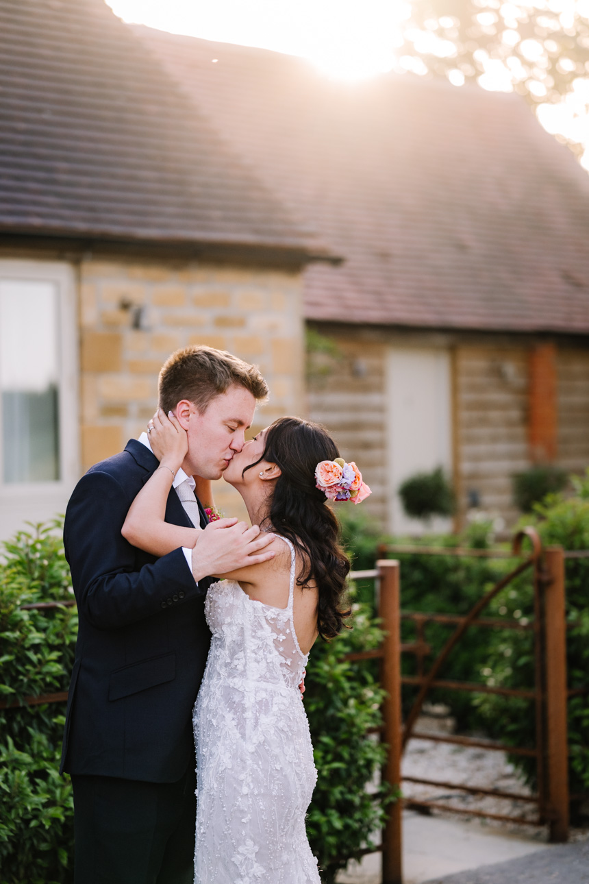 LAPSTONE BARN WEDDING PHOTOGRAPHER 44 Groom embracing his bride from behind during an outdoor wedding portrait session at Lapstone Barn.