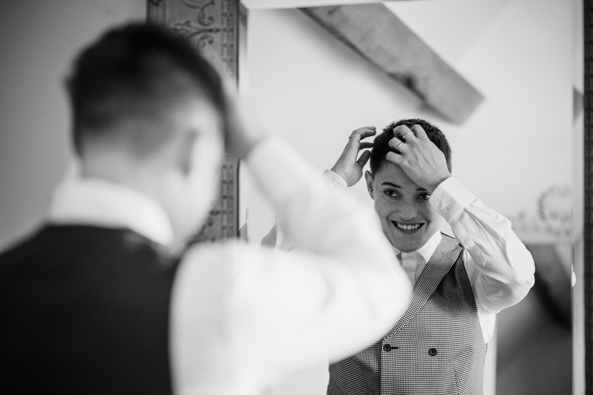 LAPSTONE BARN WEDDING PHOTOGRAPHER 16 Black and white candid photograph of a bride adjusting their hair before their LGBTQ Lapstone Barn wedding ceremony.
