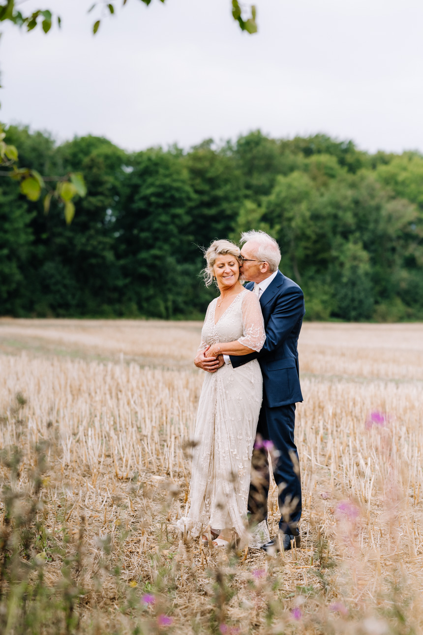 LAPSTONE BARN WEDDING PHOTOGRAPHER 63 Newlywed couple holding hands and walking through a wide open field during their wedding at Lapstone Barn.