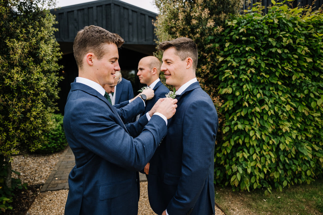 FLORA AND WILLIAM PRIMROSE HILL FARM SPRING WEDDING 18 Groom having his button hole put on at Primrose Hill Farm