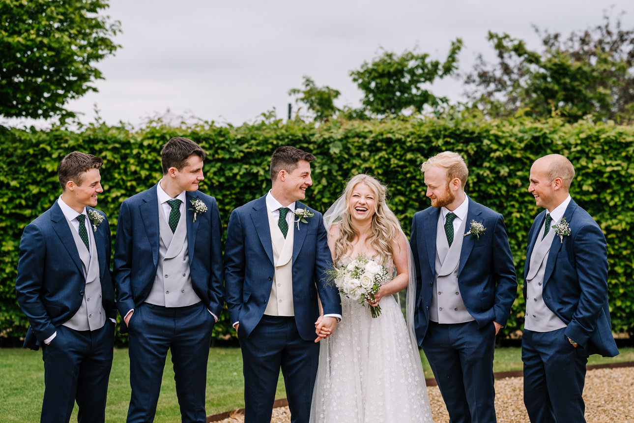 FLORA AND WILLIAM PRIMROSE HILL FARM SPRING WEDDING 40 Bride walking between her bridesmaids and groomsmen outside Primrose Hill Farm