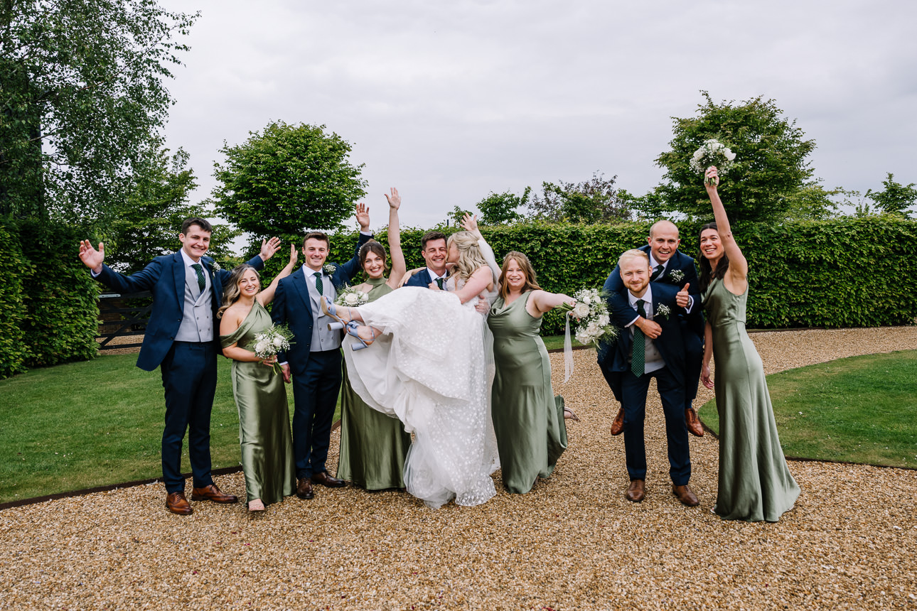 FLORA AND WILLIAM PRIMROSE HILL FARM SPRING WEDDING 41 Bride celebrating with her bridesmaids and wedding guests outside Primrose Hill Farm