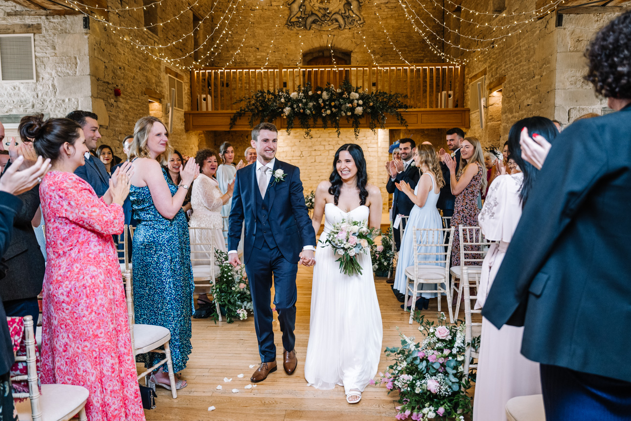 GREAT TYTHE BARN WEDDING PHOTOGRAPHER 27 Greg and Chloe making their grand entrance into their wedding breakfast under the historic oak beams of The Great Tythe Barn.