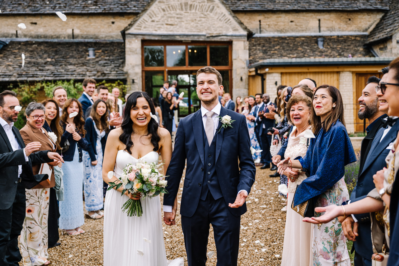 GREAT TYTHE BARN WEDDING PHOTOGRAPHER 28 happy couple covered in confetti at the Great Tythe Barn In tetbury