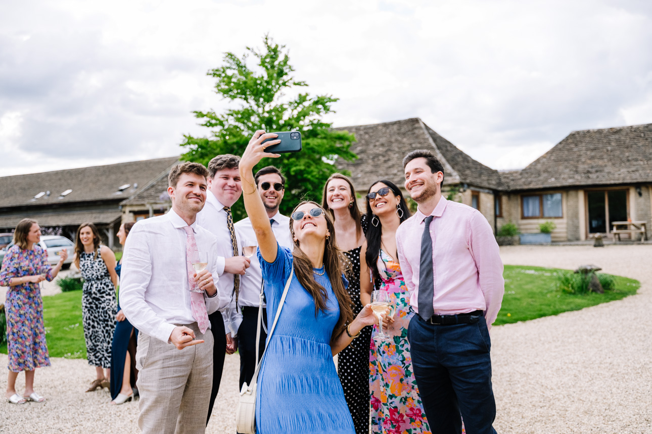 GREAT TYTHE BARN WEDDING PHOTOGRAPHER 12 guests taking a selfie at the great tythe barn