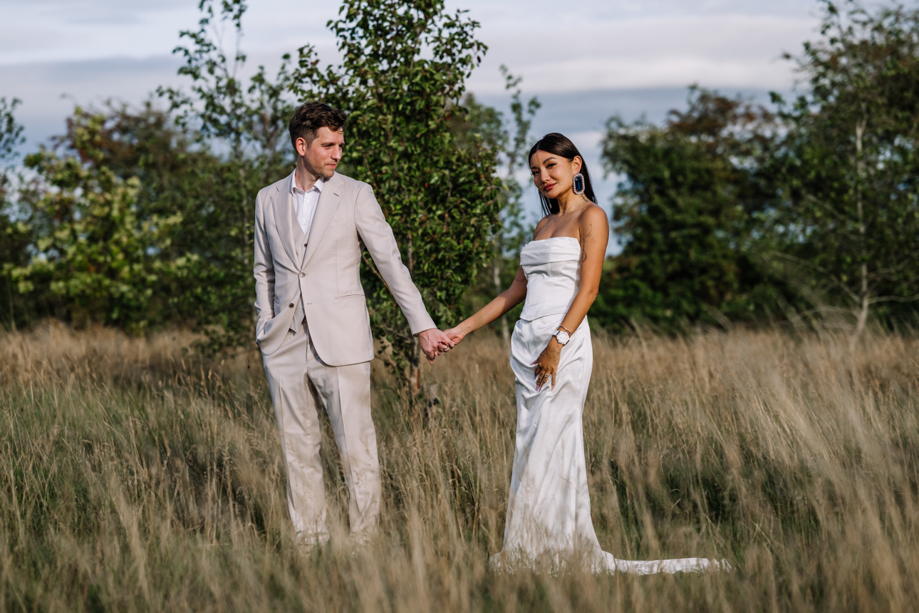 OXLEAZE BARN WEDDING PHOTOGRAPHER 60 Couple holding hands in the tall grass at Oxleaze Barn