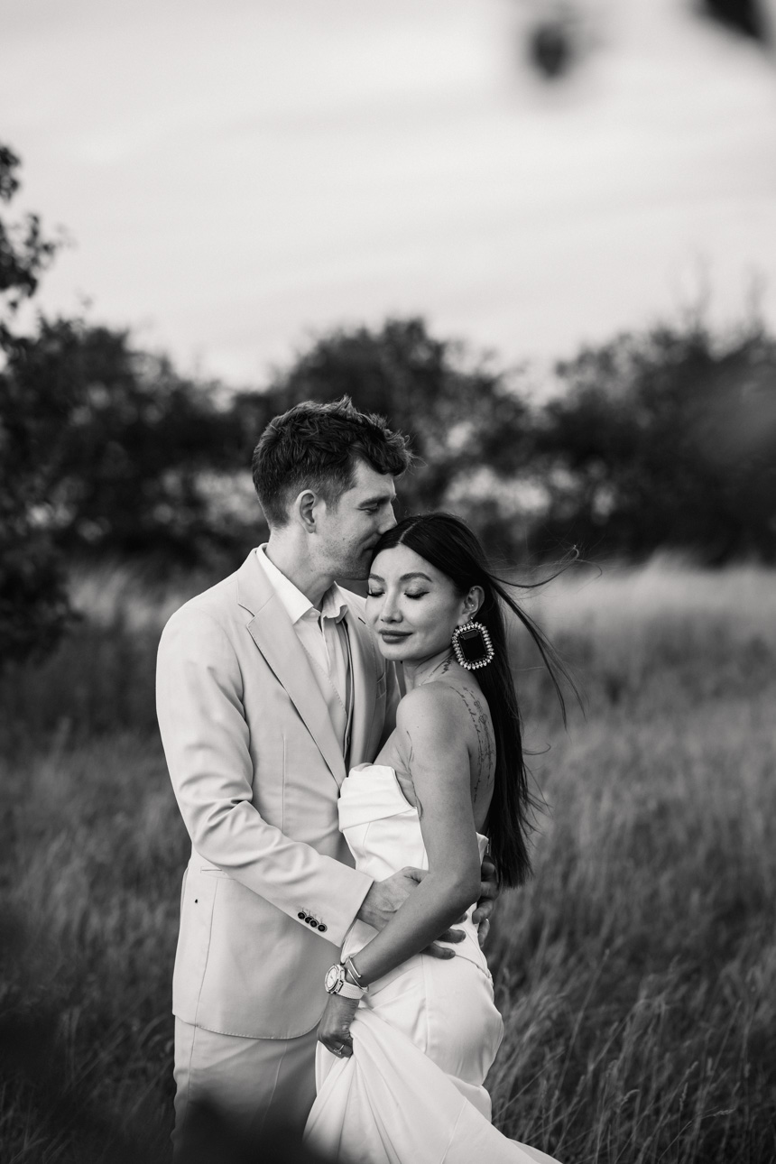 OXLEAZE BARN WEDDING PHOTOGRAPHER 82 Black and white photo of couple embracing at Oxleaze Barn in the summer